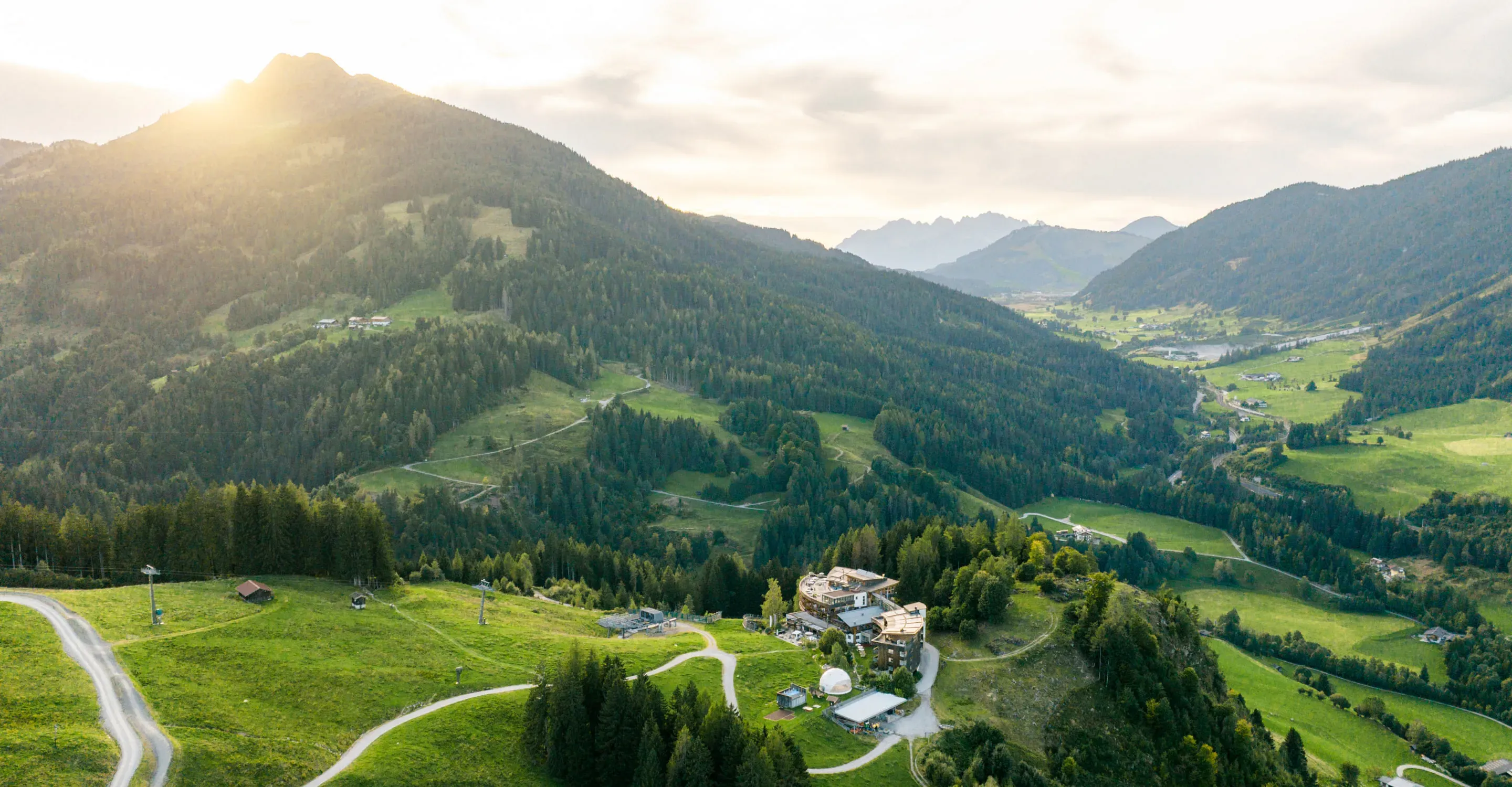 Landscape shot of mountains and a farmhouse